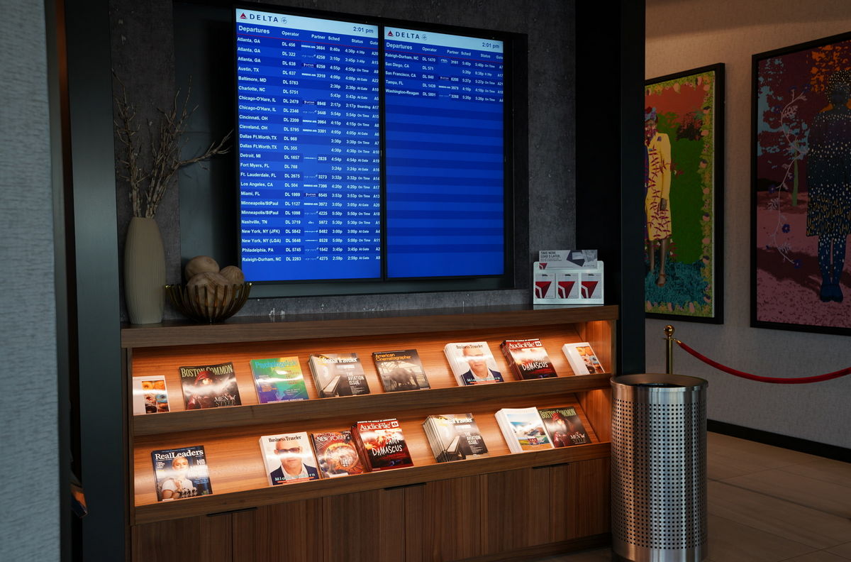 magazines and flight information board showing delta flights.