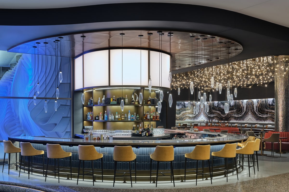 Full bar with seats around the bar area and lights hanging from the ceiling.