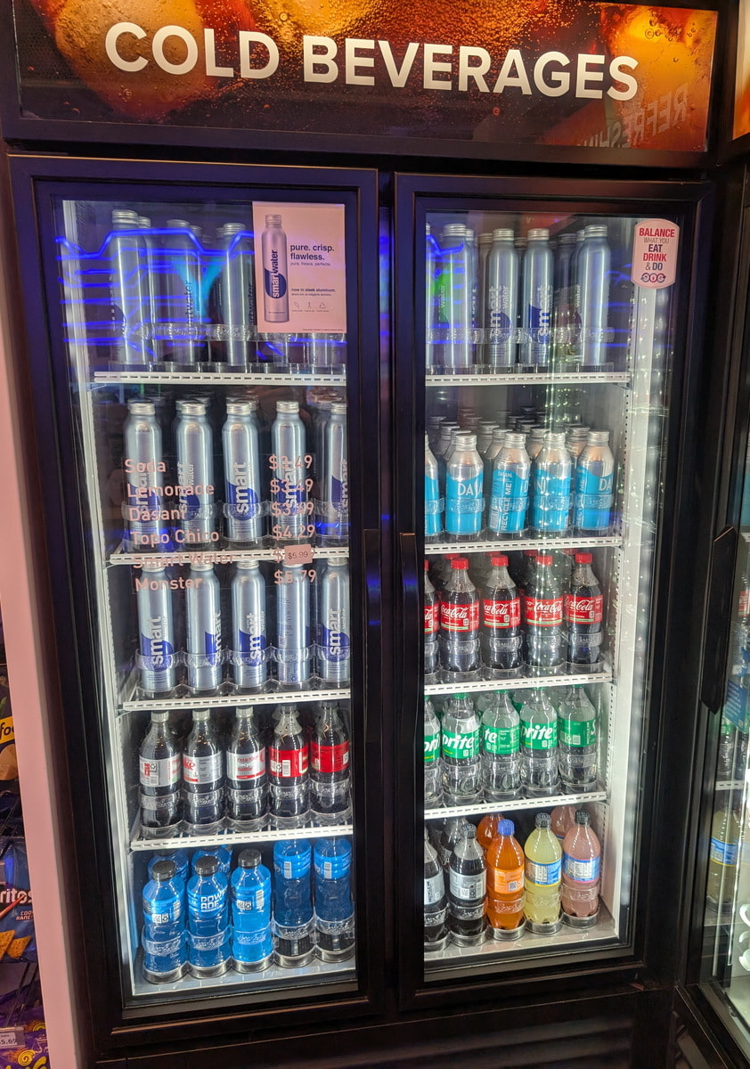 beverage fridge with drinks and bottles.