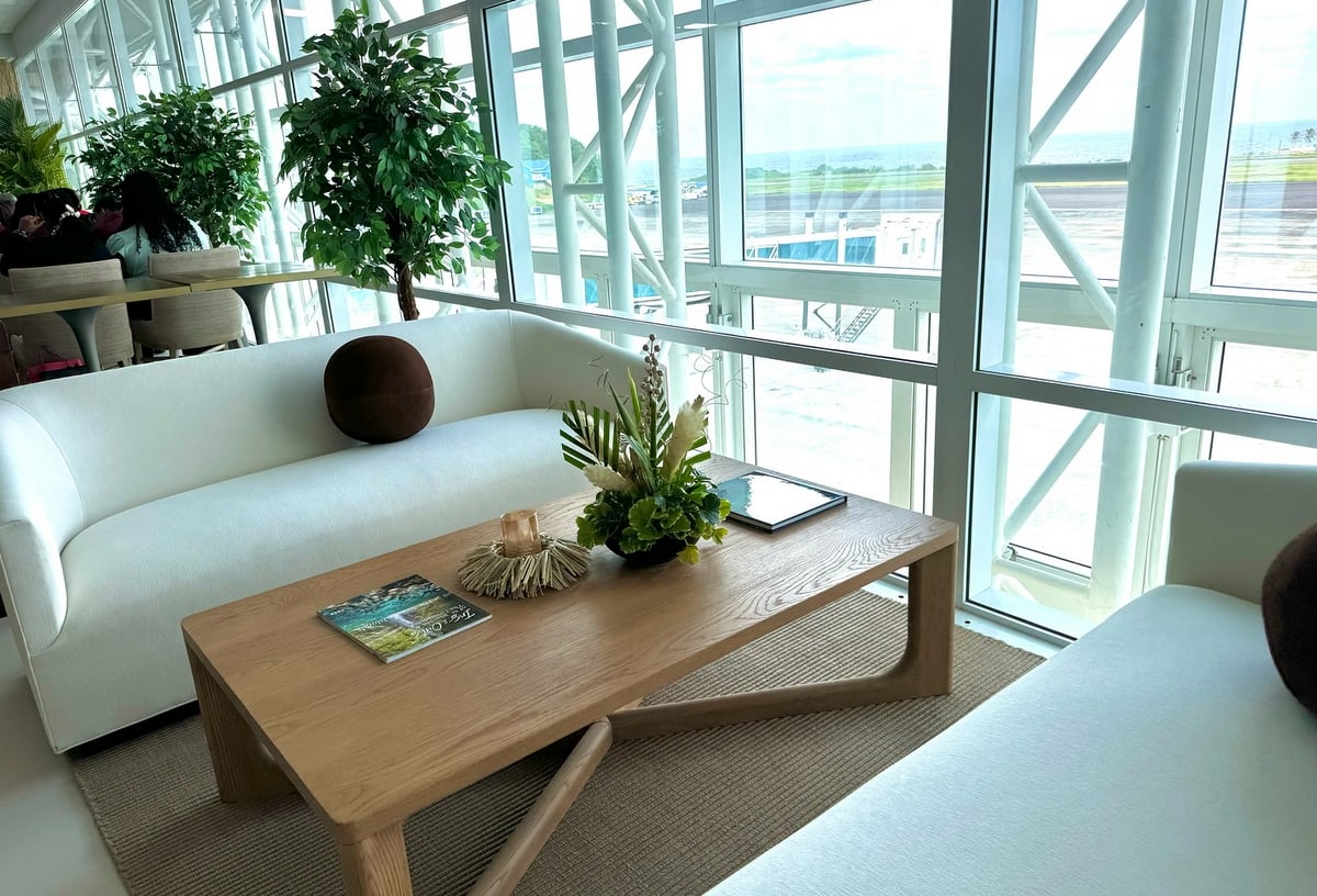 Sofas and table next to the windows with view of the gate area.