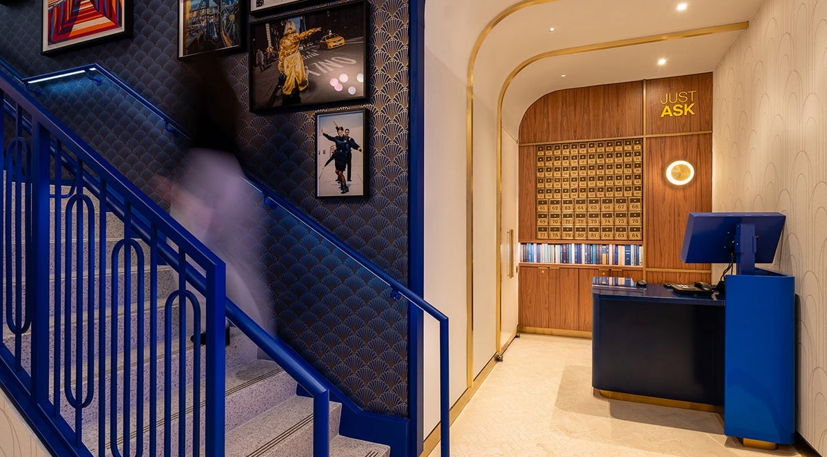 Entrance area of the JFK BlueHouse lounge, with desk and stairs.