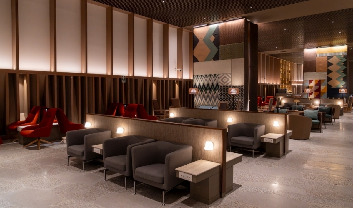 Seating area with chairs, warm lighting and tables in the LATAM lounge in Lima.