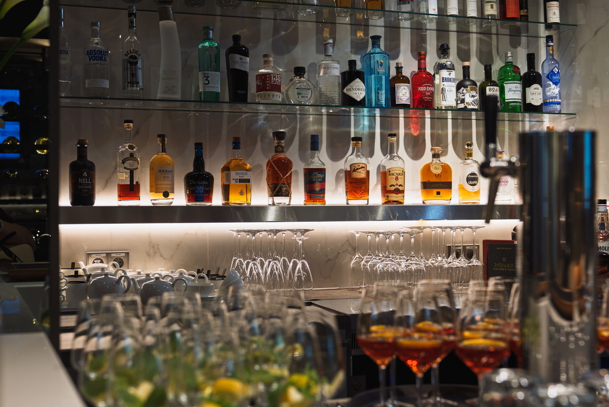 bar area, with bottled liquor on the back wall and glassware hanging.