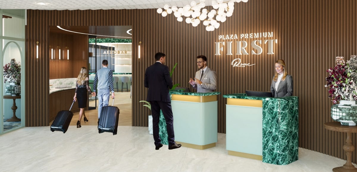 people standing at the entrance desk and two people walking in to the lounge behind the desk.