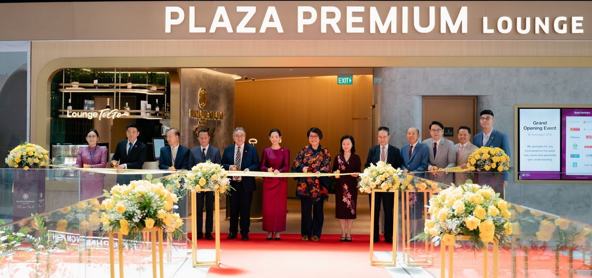 A group of people in front of the Plaza Premium Lounge at Techo airport cutting a ribbon.