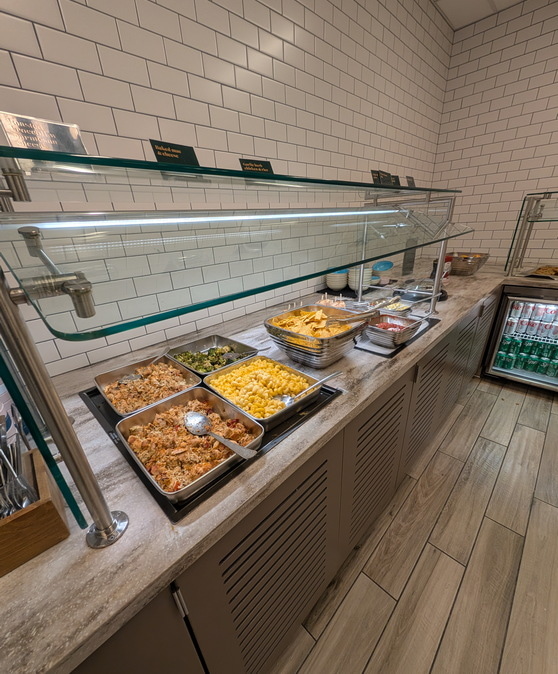 Food including mac and cheese, broccoli, and chips on the buffet bar.