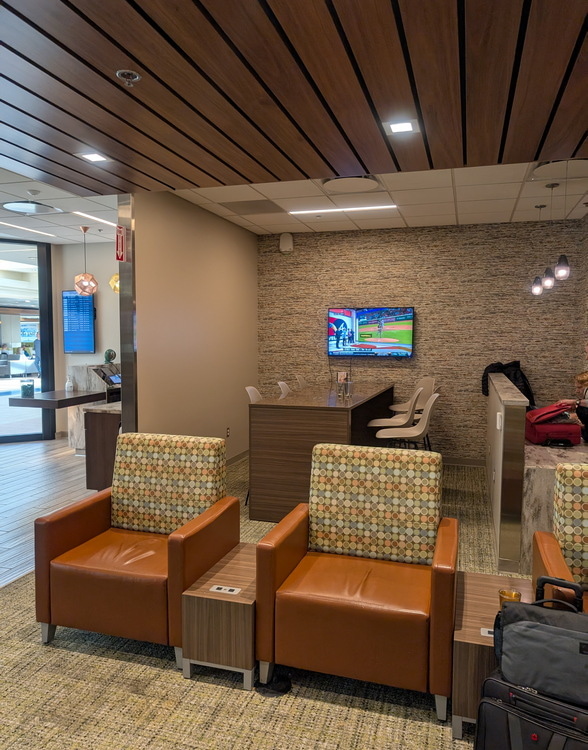 Tables and seating area with TV in the background.