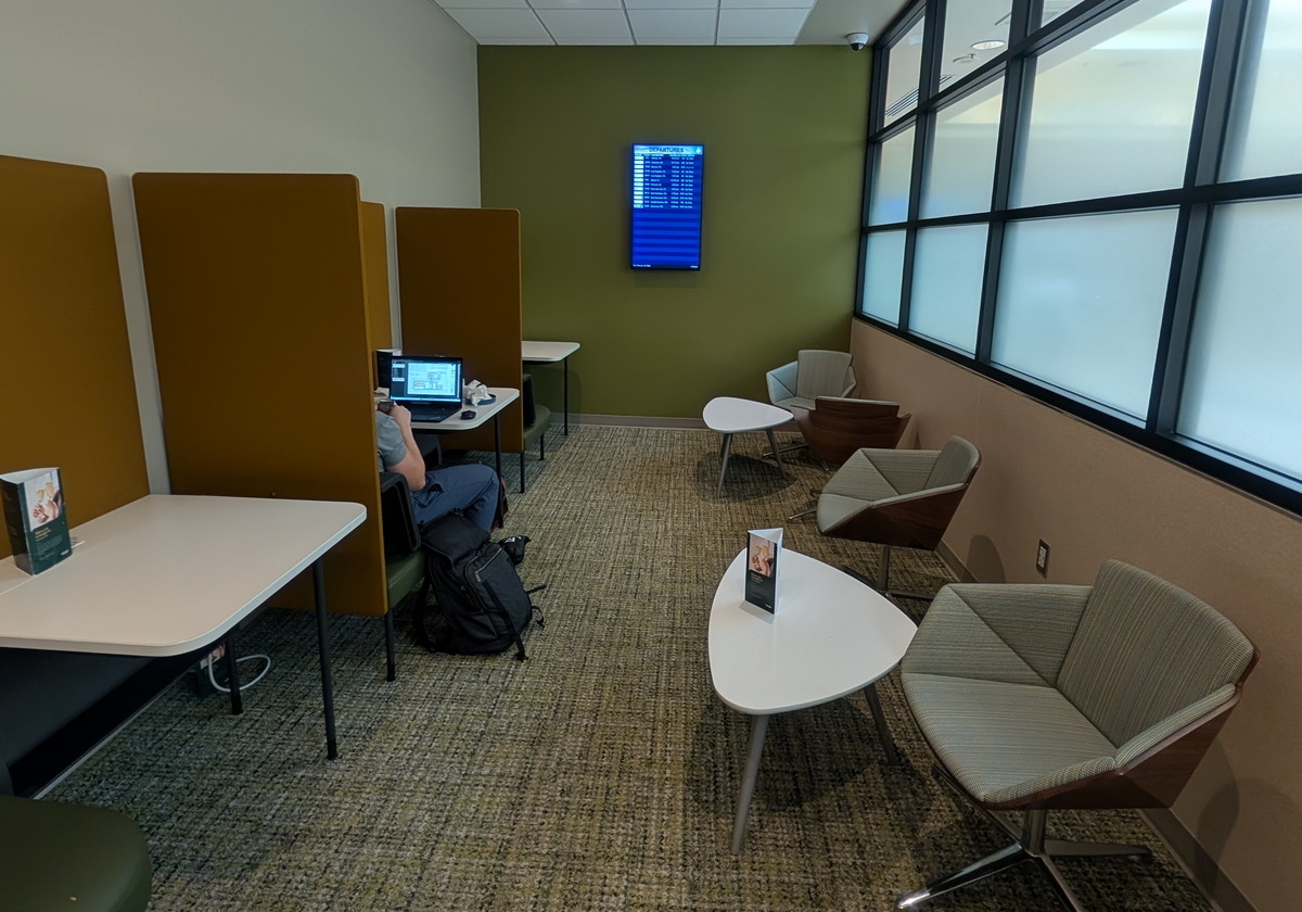 Seating and work area to with a flight monitor and tables.