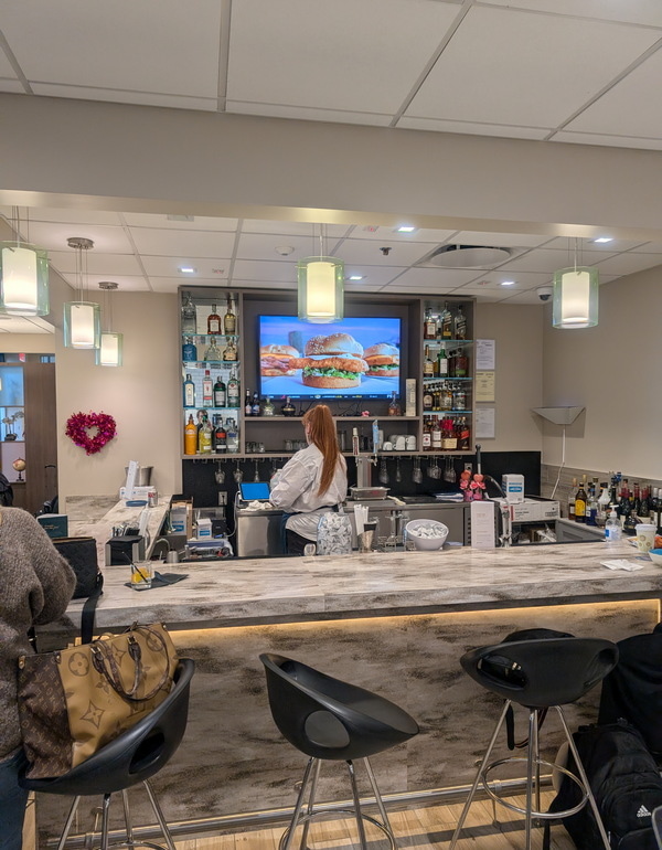 the bar area with bottles on the back and a tv.