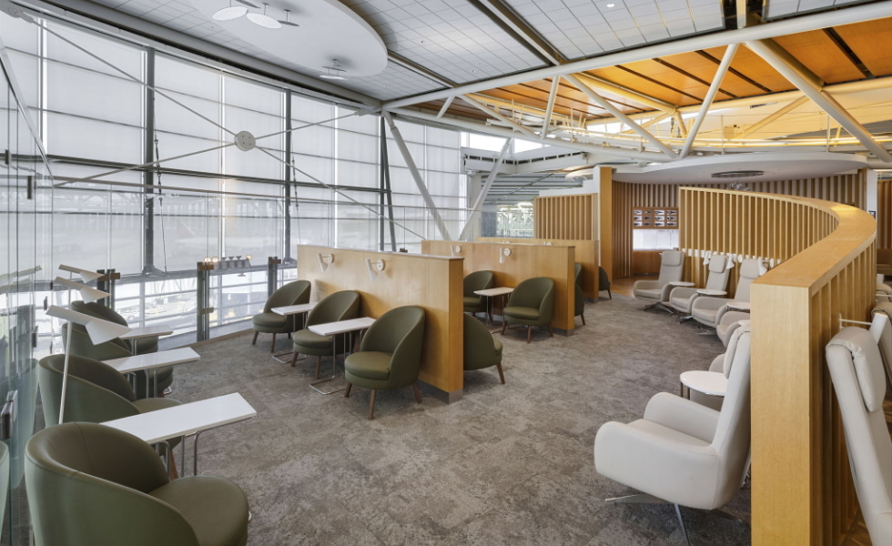 Seating area with small tables and floor-to-ceiling windows.