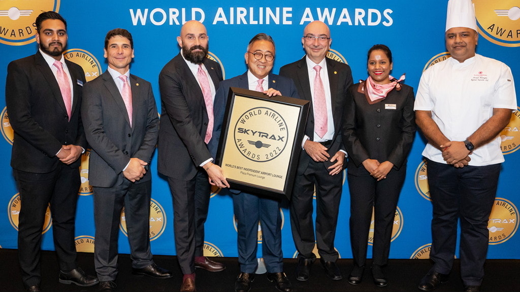 Six people posing holding up award for best independent lounge award.