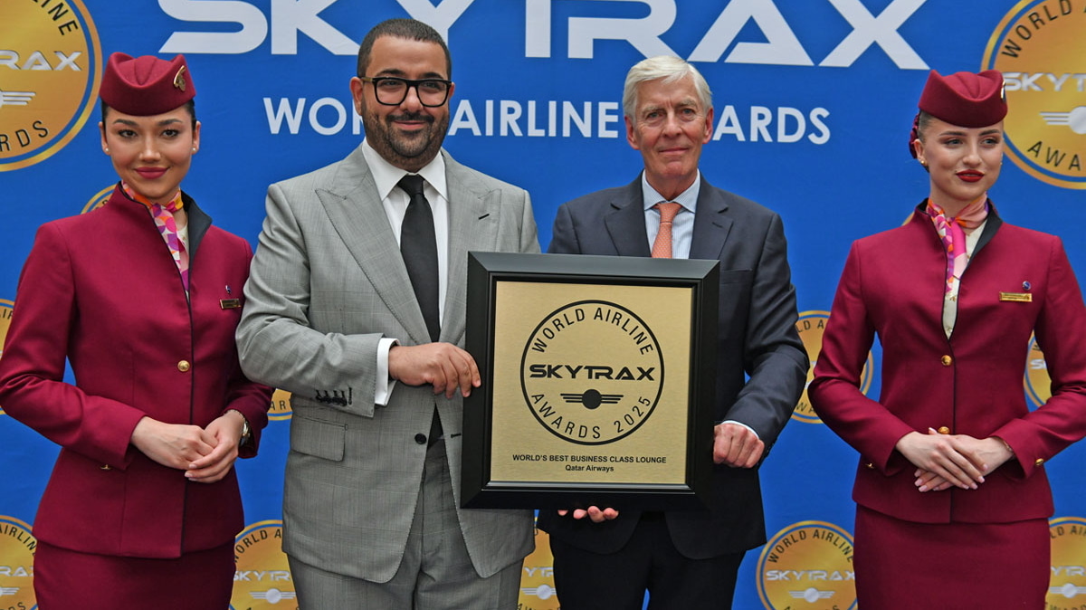 Four people standing on stage with the award for best business class lounge.