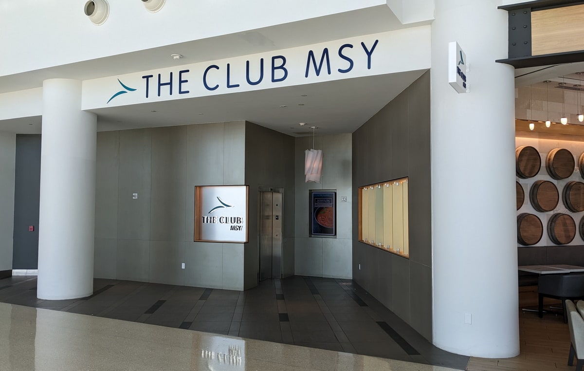 The front entrance downstairs to the lounge, with a sign reading The Club MSY and an elevator down a small corridor.