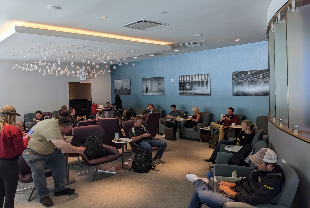 main seating area with chairs and tables, and many people.
