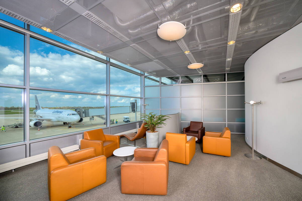 Chairs and tables with a view out the window of the lounge.