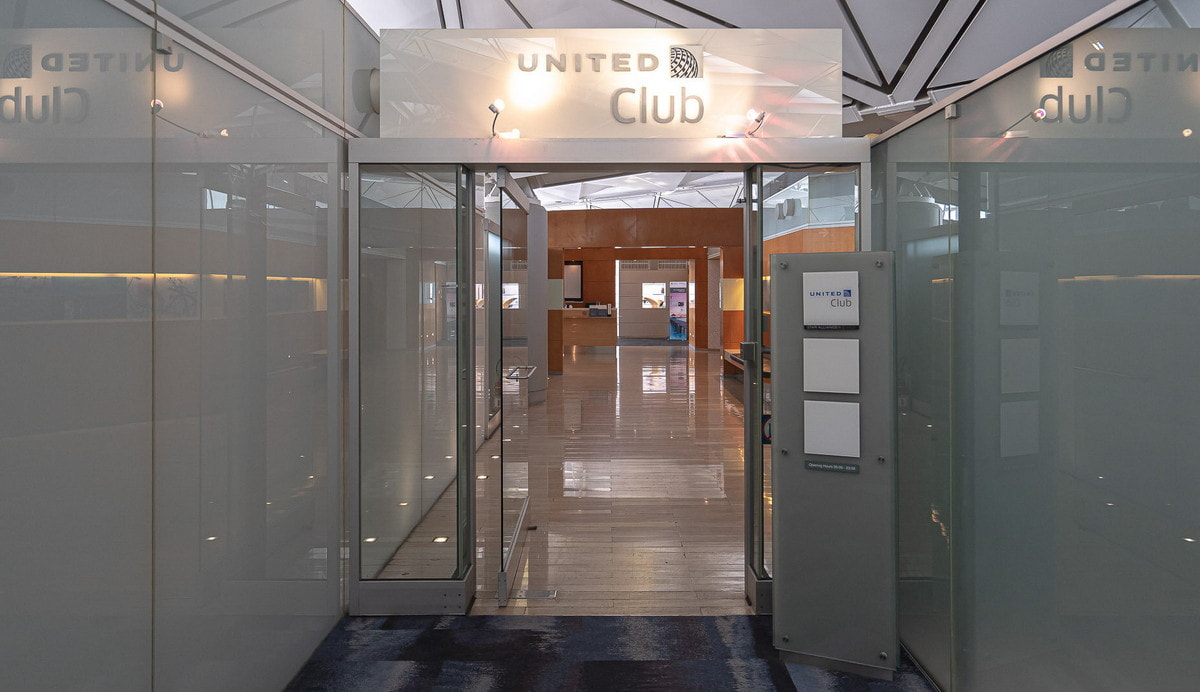 Entrance of the United Club at Hong Kong airport, showing doors and a hallway.
