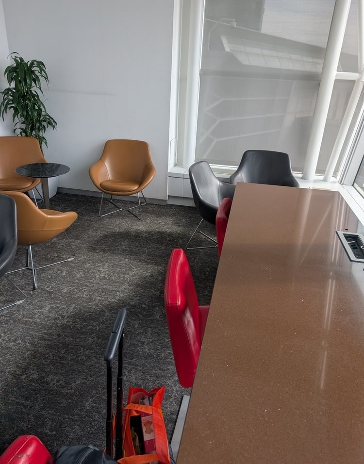 corner seating area with small table and a large window table with chairs and chargers.