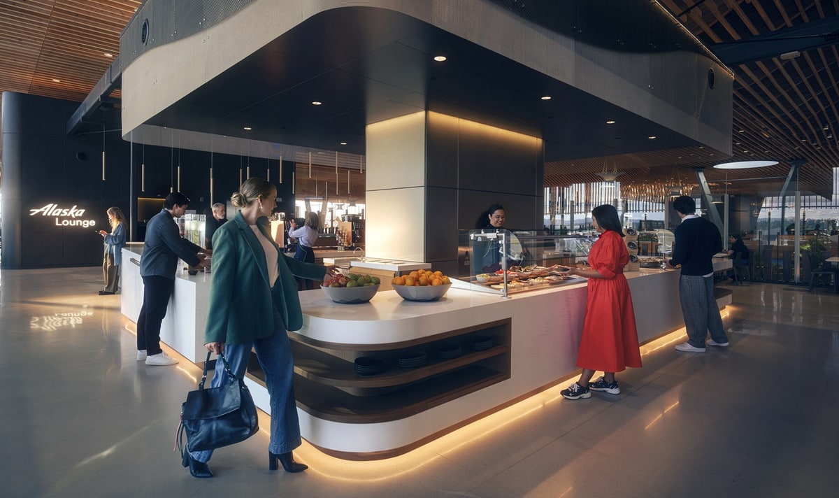 People walking around and grabbing food from the buffet area at the new lounge.