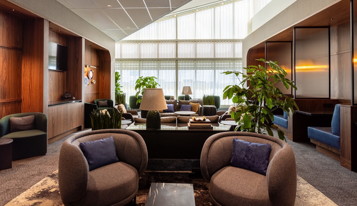 seating area with sofas, booths, and windows in the background.