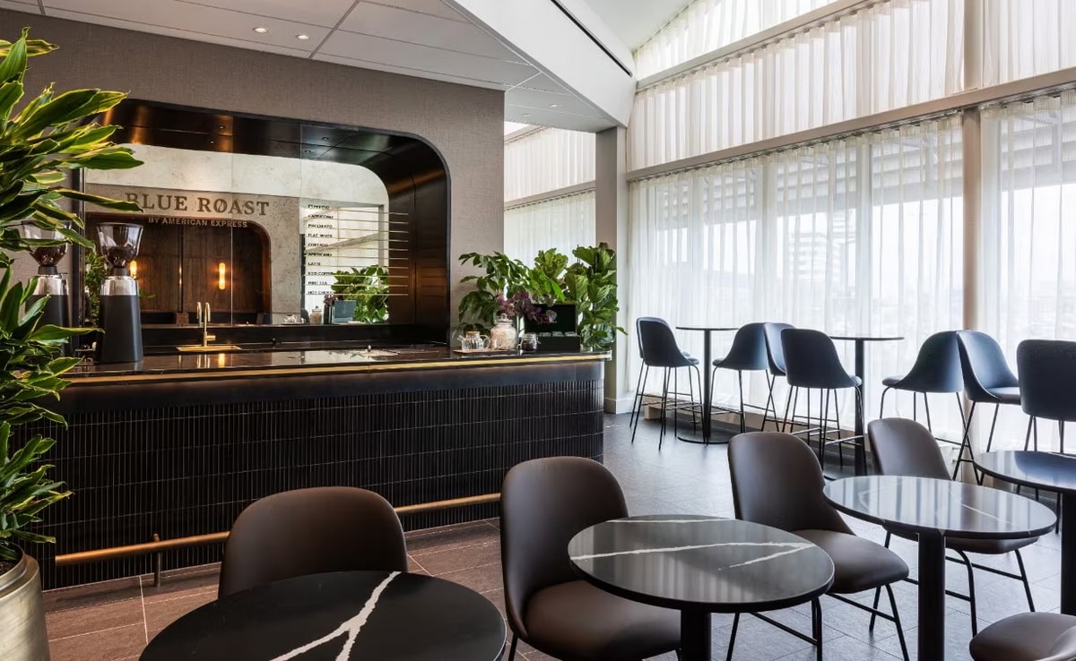 coffee bar with menu, and seating area with tables.