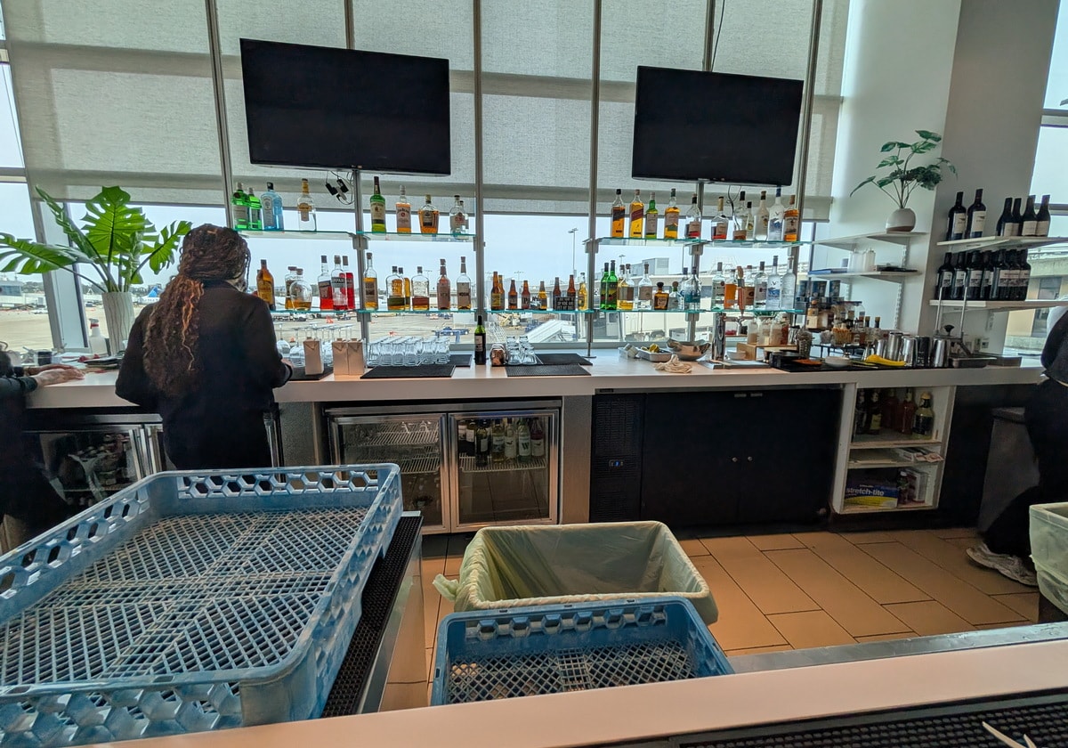 bar area with an employee behind the bar and bottles of alcohol.
