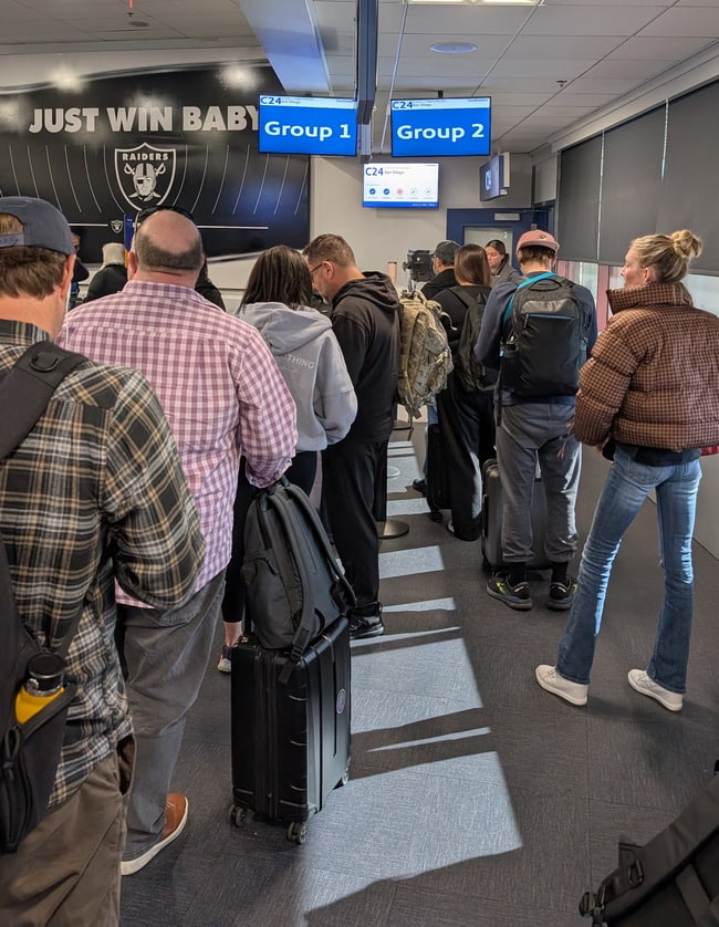 people waiting in line to board airple Group 1 and Group 2.