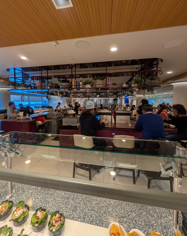 bar area near the food serving section, with people sitting at the bar.