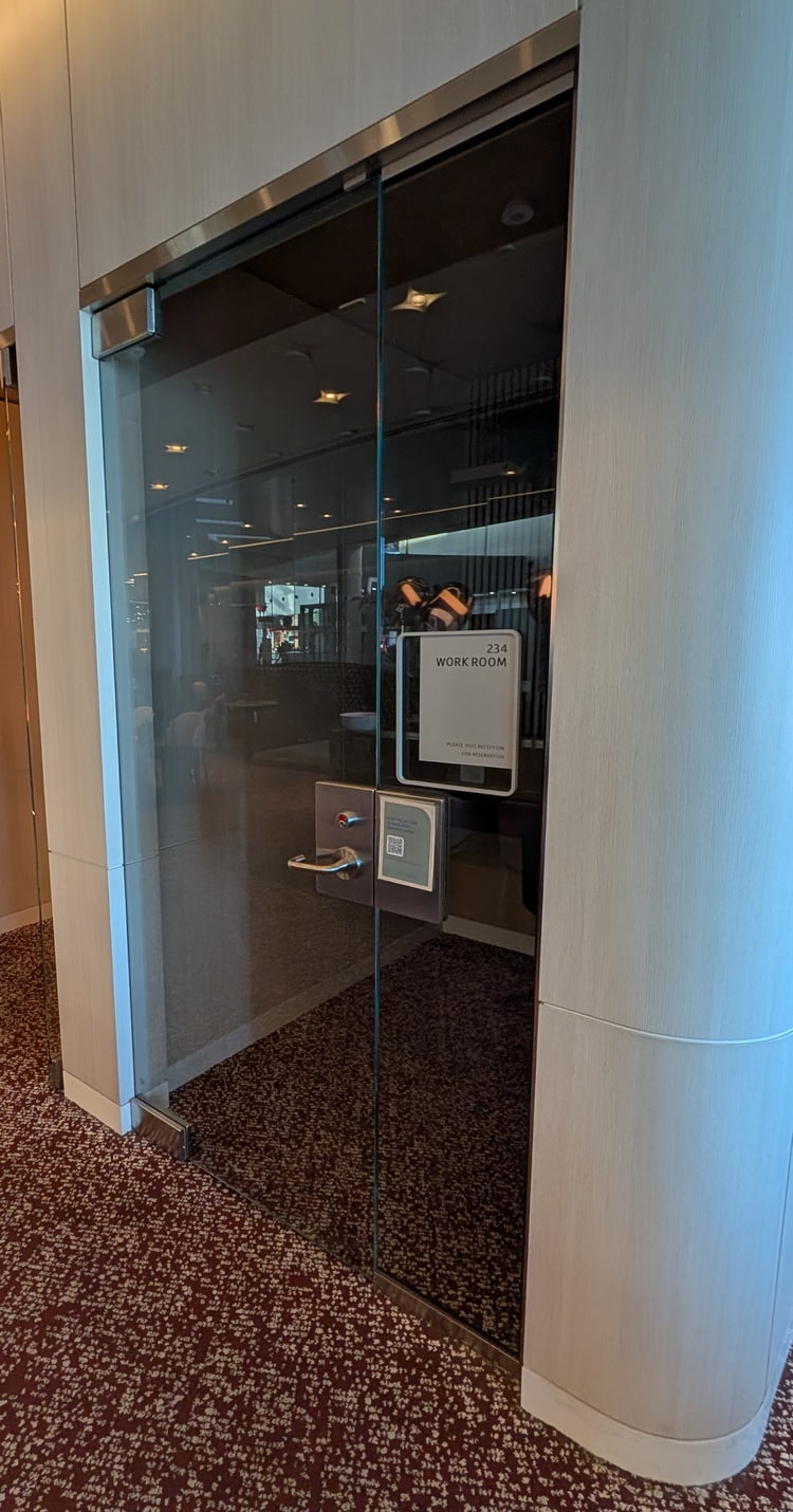 view from outside the workroom, with glass enclosure and seating.