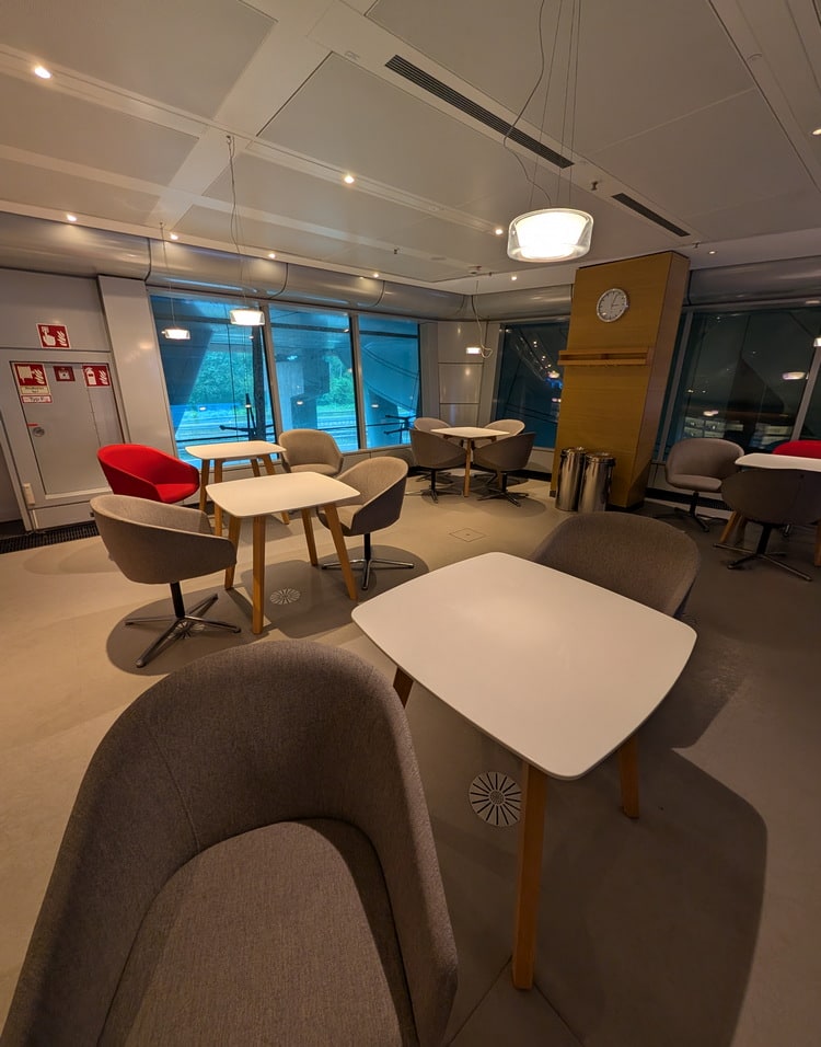 bistro area with tables, seating, coat rack, trash.
