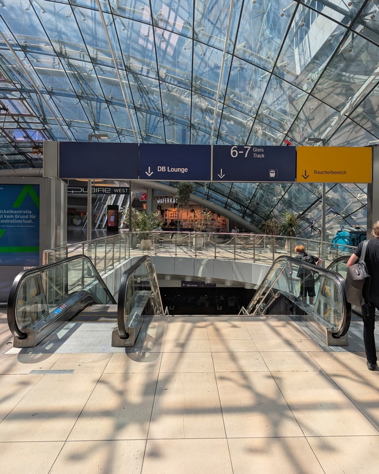 sign pointing down to the DB Lounge, from the escalator.