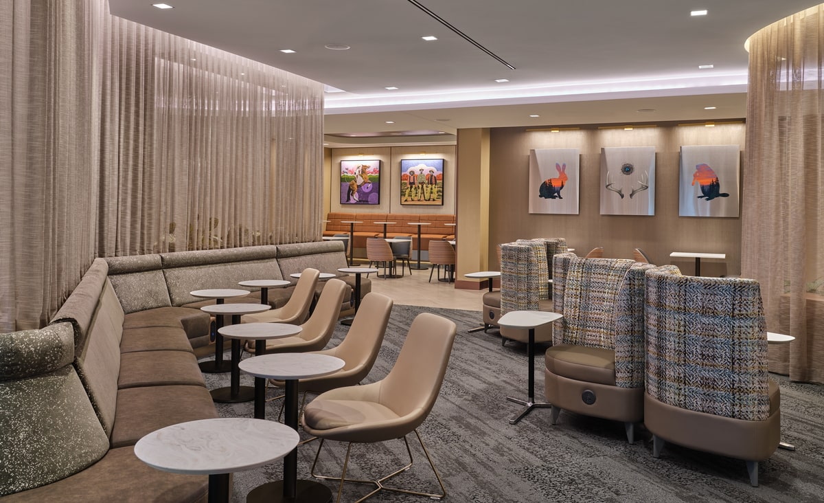 seating area with art on the walls, as well as tables and chairs.