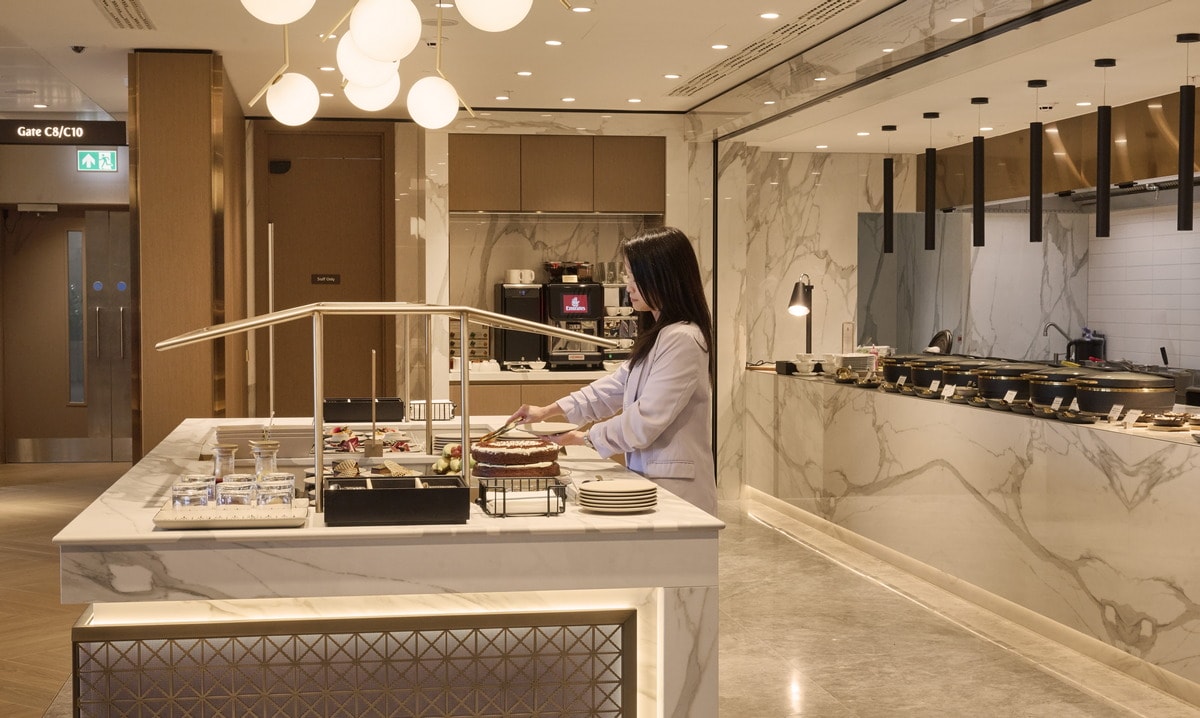 self-serve food area with a person selecting items from the dessert bar.