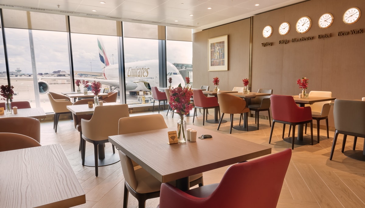 dining area with tables and chairs, and floor-to-ceiling windows.