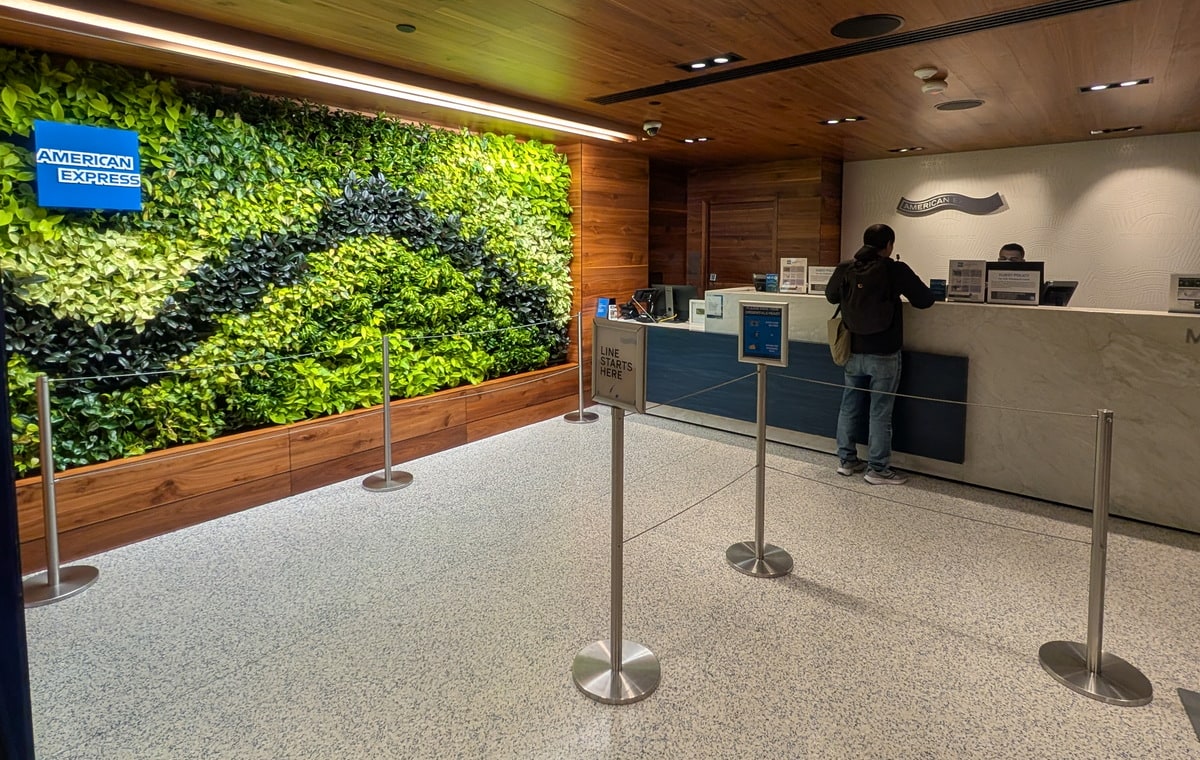 Front desk and entrance inside of the LAX Centurion lounge with one person at the desk.
