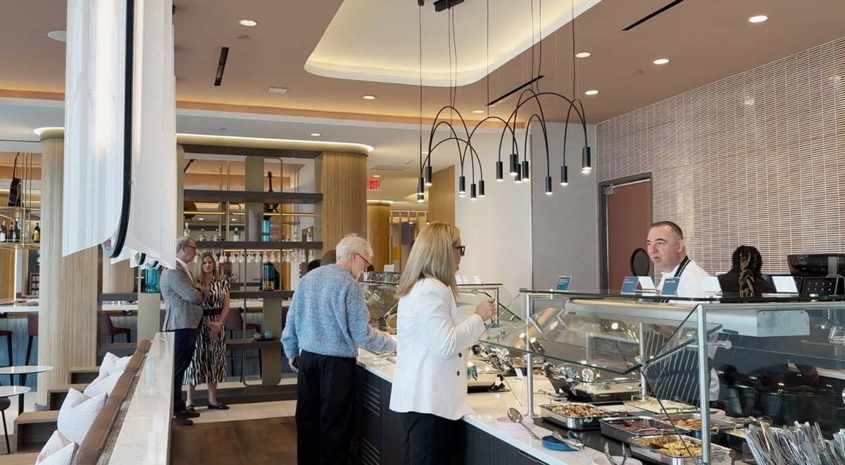 buffet area with people talking and the bar in the background.