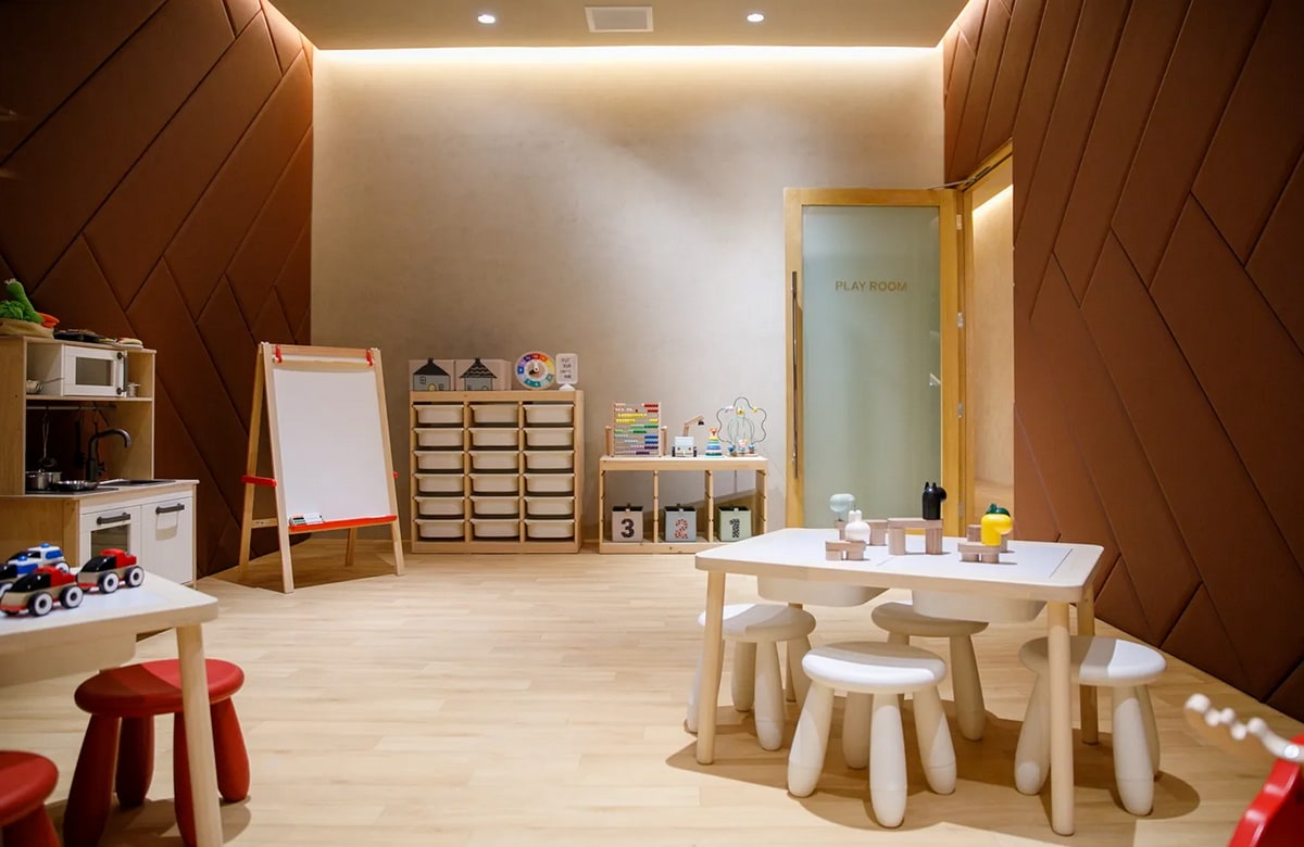enclosed kids play room with toys and small tables.