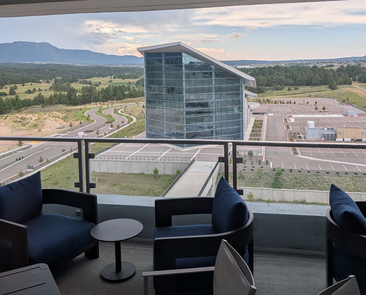 Outdoor patio with tables and seating, view of the mountains in the background.