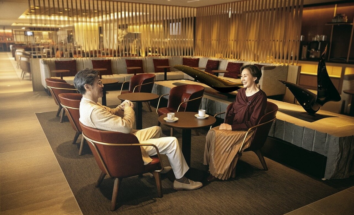 two people sitting down having a drink talking in lounge.