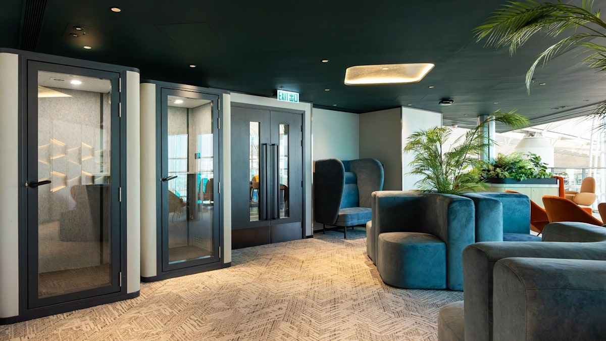 seating area with tables, sofas, and sound-proof phone booths.