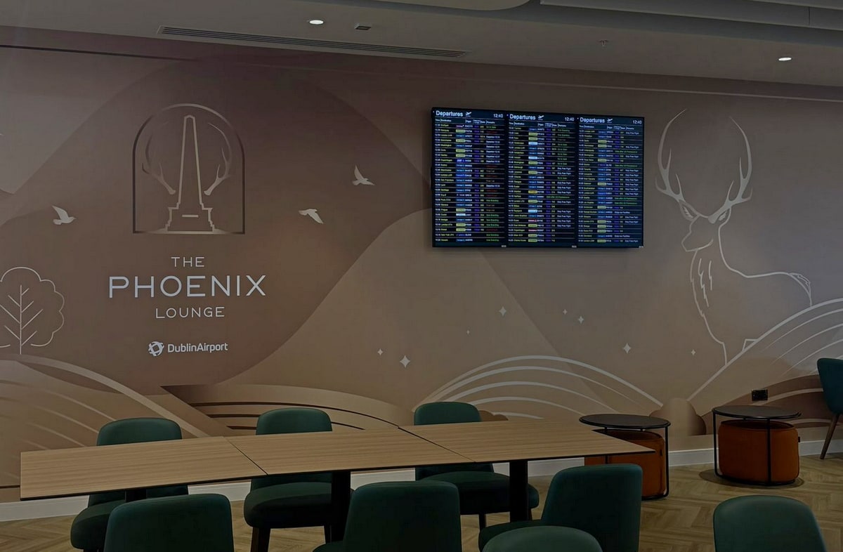 Tables and seating area with flight monitors on the back wall.