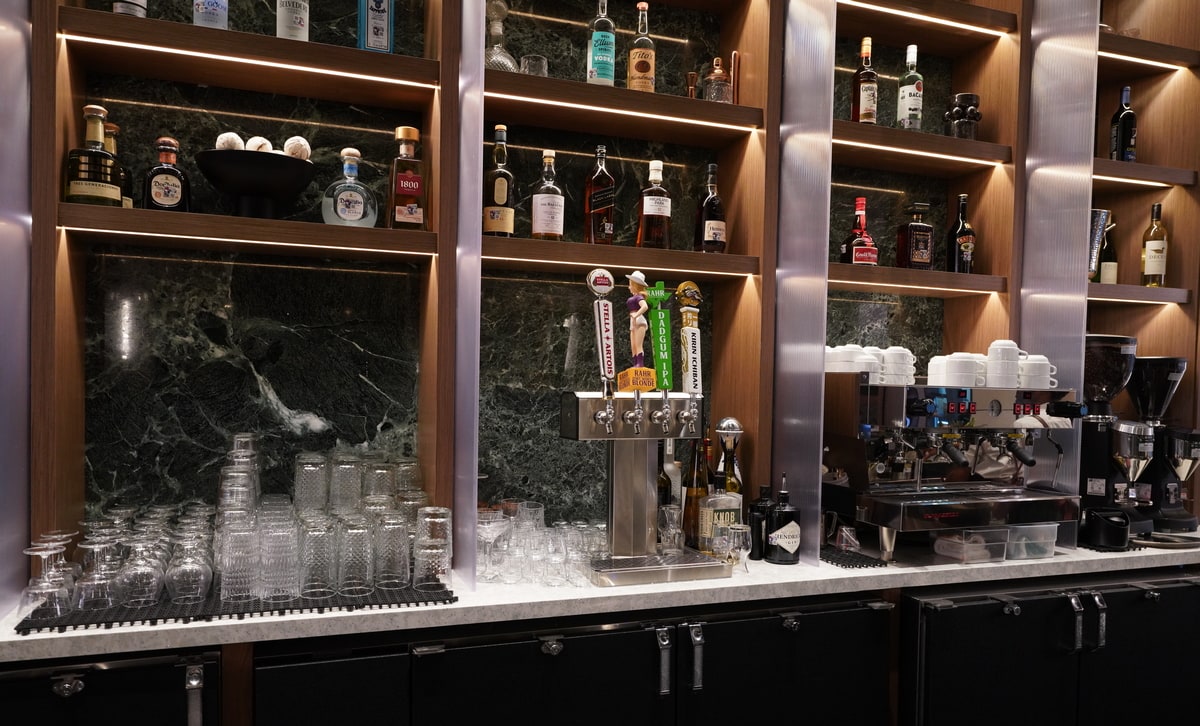 bar showing bottles on the wall as well as an expresso machine.