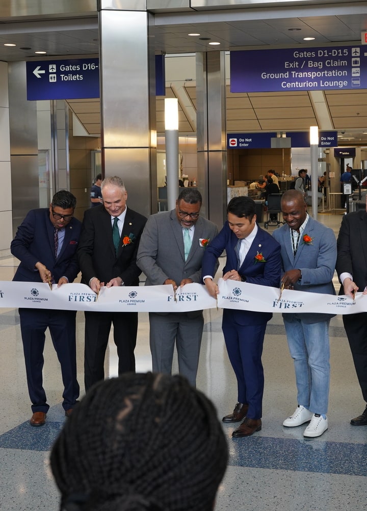 multiple people cutting the ribbon for the grand opening.