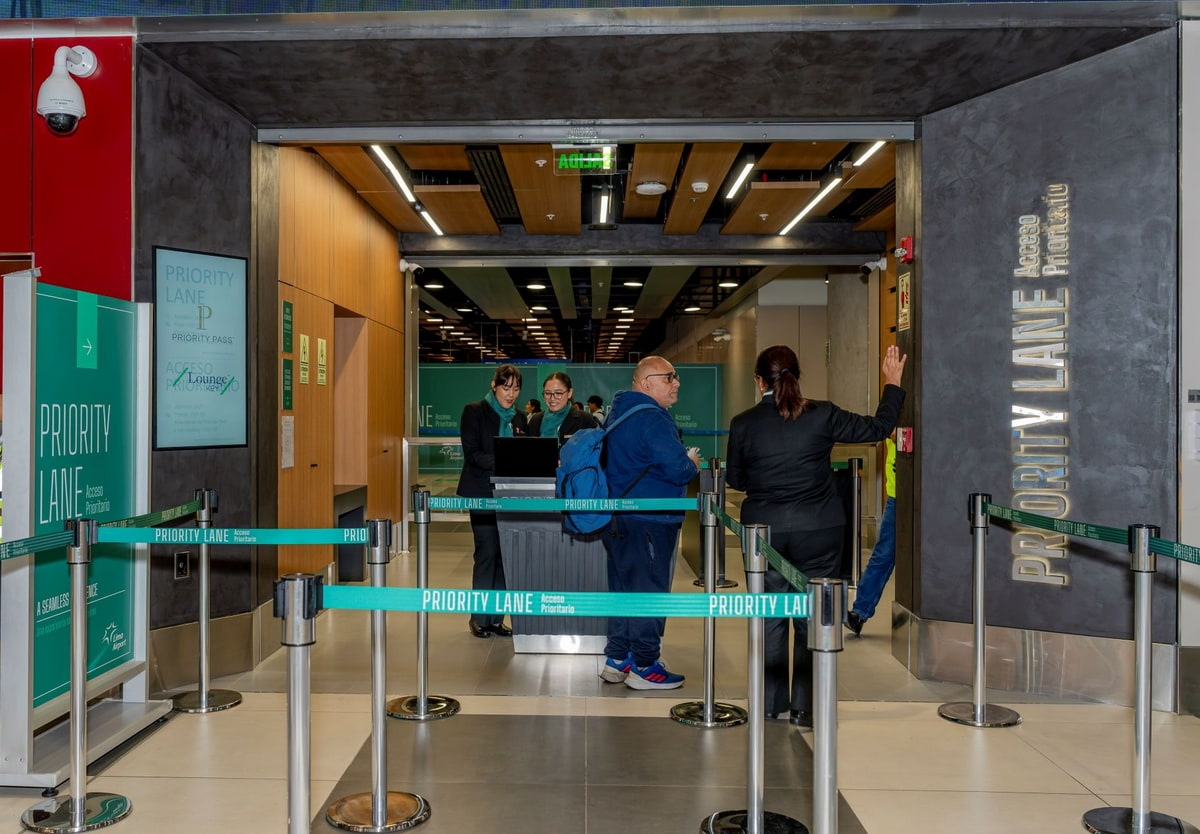 Priority Lane with reception desk and line markers, and two people standing in line.