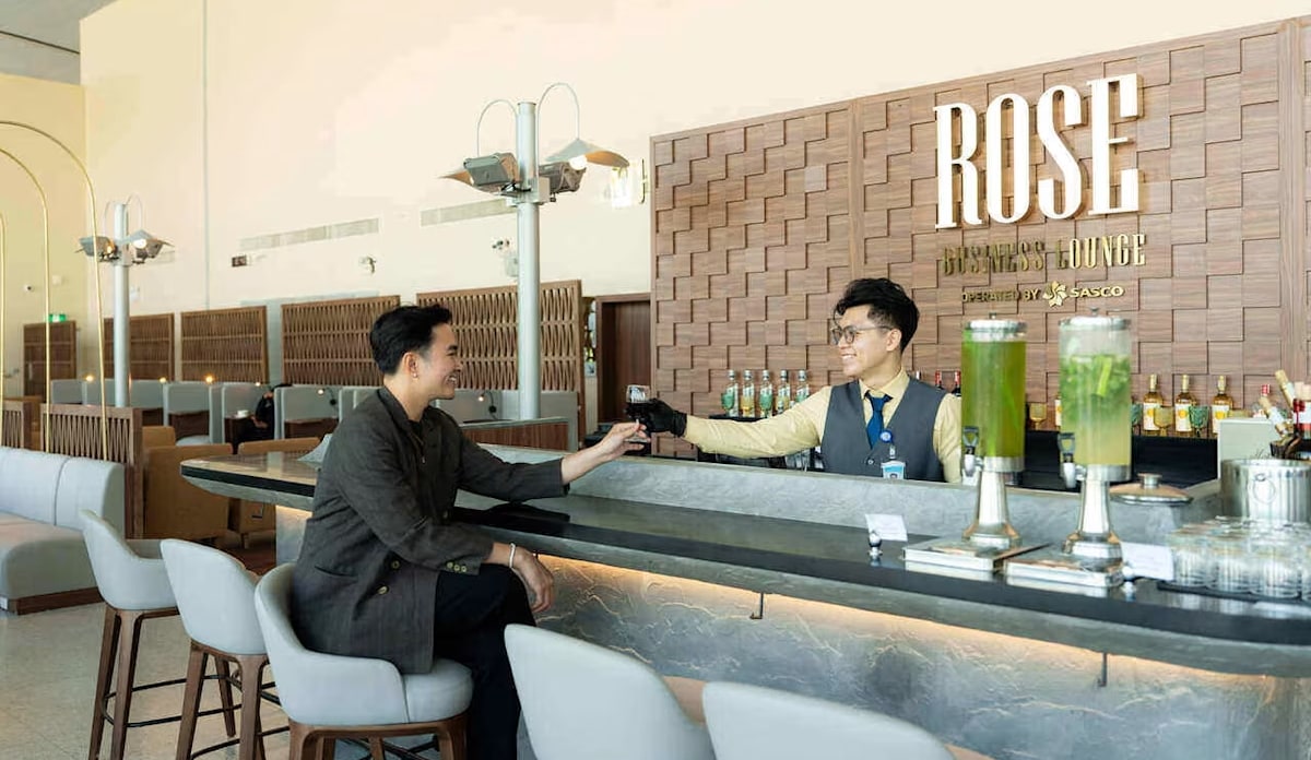 Person sitting at the bar with a bartender serving drink.