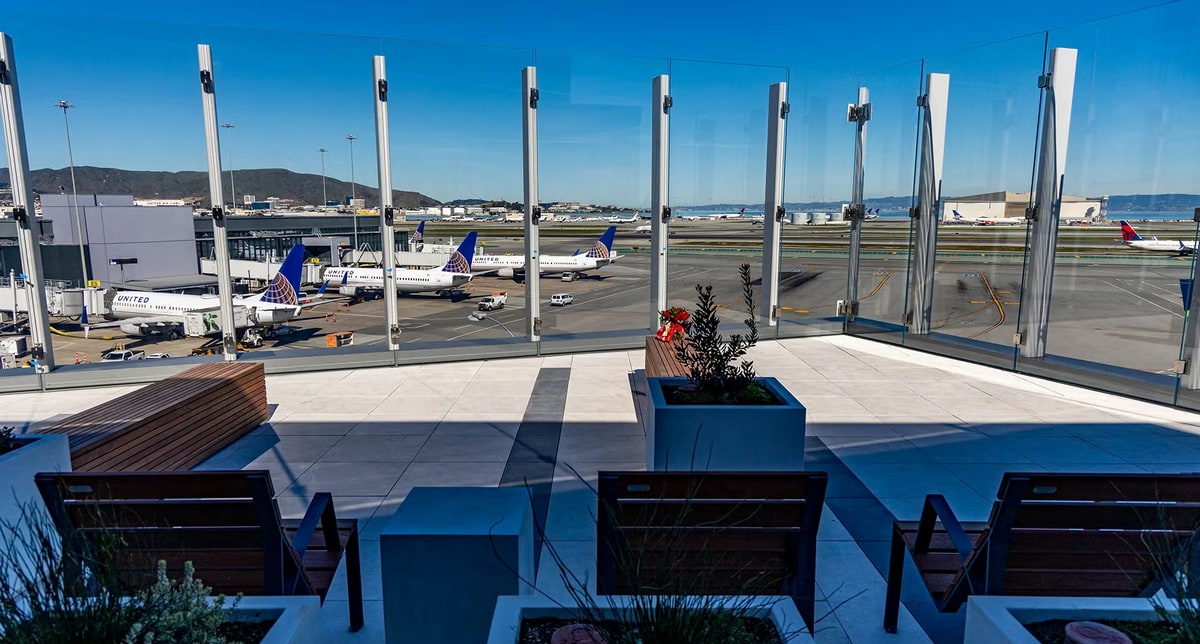 View of the SkyTerrace patio with seating and glass, views of airplanes in the background.