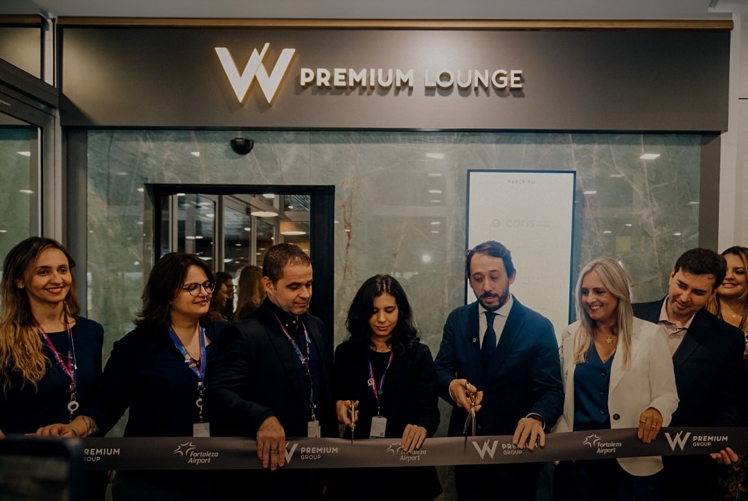 People standing out from of the W Premium lounge cutting a grand opening ribbon.
